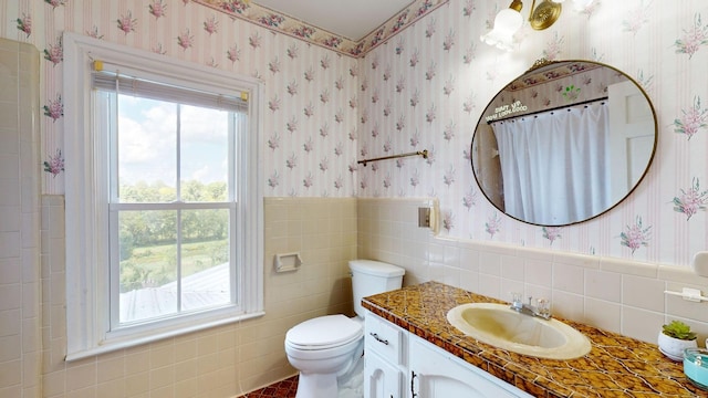 bathroom with vanity, tile walls, and toilet