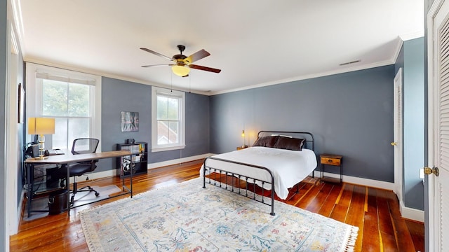 bedroom featuring hardwood / wood-style flooring, ornamental molding, and ceiling fan