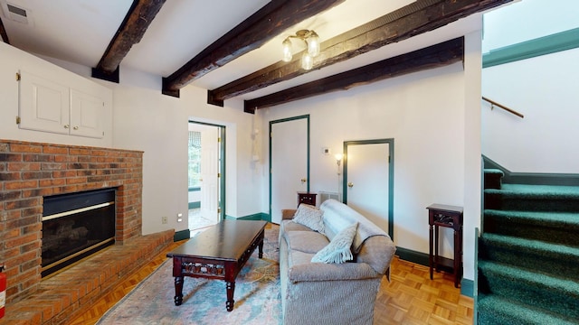 living room featuring beam ceiling, a brick fireplace, and light parquet floors