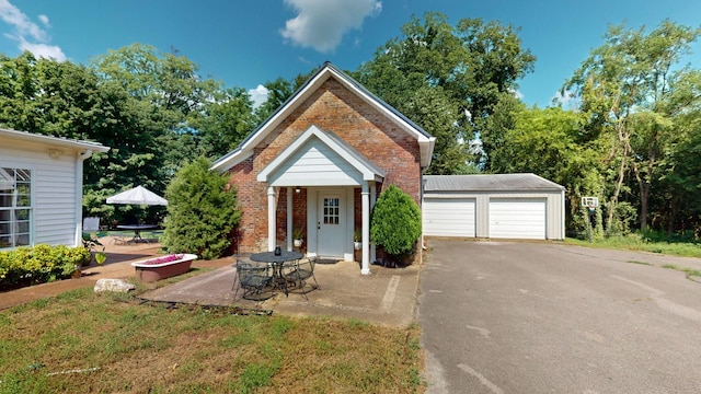 view of front of house with a garage, an outdoor structure, and a patio