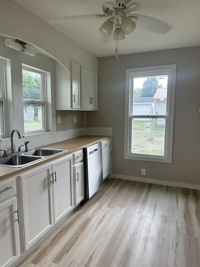 kitchen with sink, ceiling fan, white cabinetry, a textured ceiling, and stainless steel dishwasher