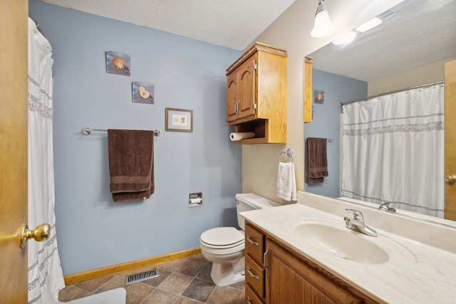 bathroom featuring vanity, toilet, tile patterned floors, and a textured ceiling