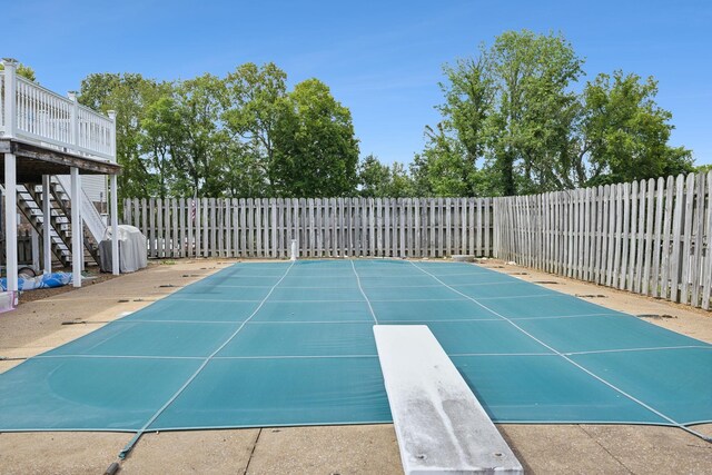 view of pool featuring a deck and a diving board