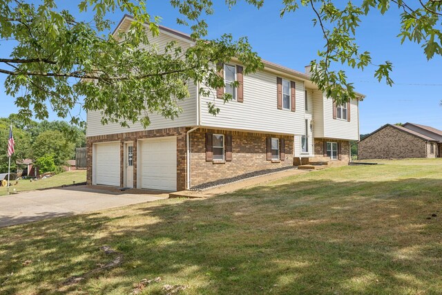 raised ranch featuring a garage and a front yard