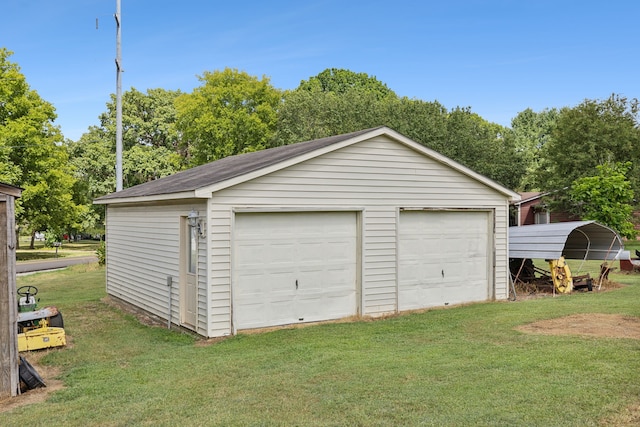 garage featuring a carport and a yard