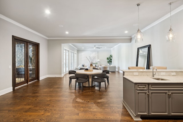 dining room featuring crown molding, sink, dark wood-type flooring, and ceiling fan