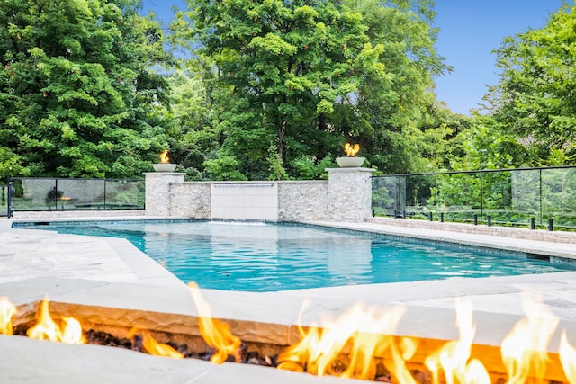 view of pool featuring an outdoor fire pit and pool water feature