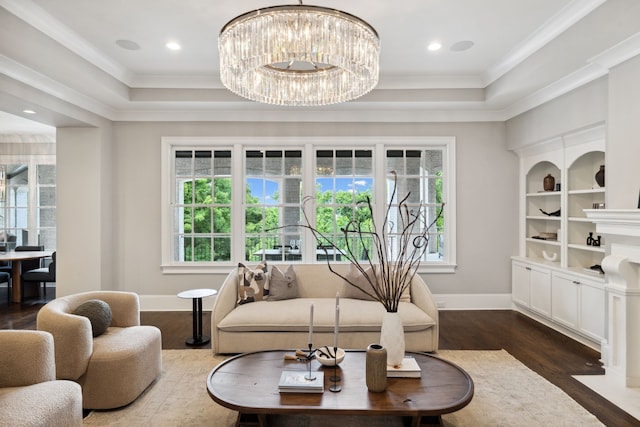 living room with ornamental molding, a chandelier, a tray ceiling, and dark hardwood / wood-style flooring