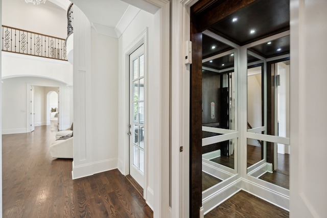 entryway with elevator, french doors, dark hardwood / wood-style floors, and ornamental molding