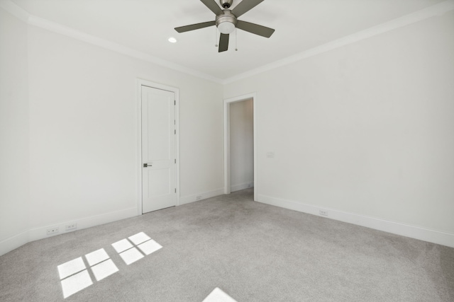 unfurnished room featuring ceiling fan, crown molding, and light colored carpet