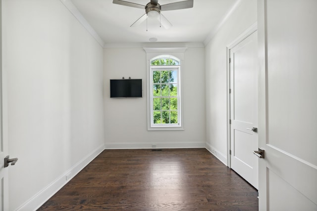 spare room with ornamental molding, dark wood-type flooring, and ceiling fan