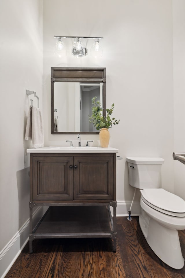 bathroom with toilet, hardwood / wood-style flooring, and vanity