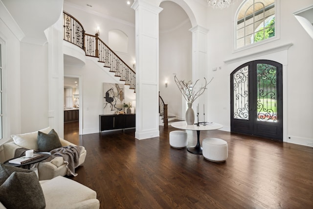 foyer entrance with french doors, decorative columns, a high ceiling, and dark hardwood / wood-style floors