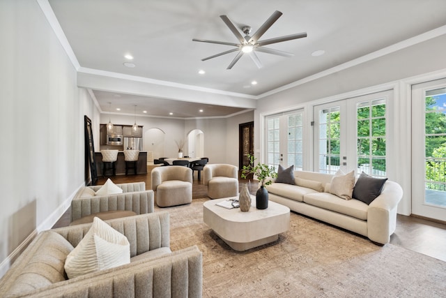 living room featuring light hardwood / wood-style floors, french doors, ceiling fan, and crown molding