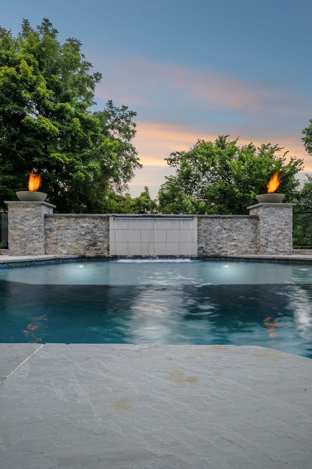 pool at dusk with pool water feature