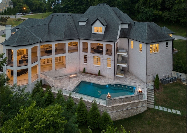 rear view of property featuring a patio area and a balcony