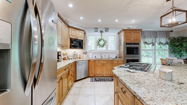 kitchen with crown molding, light stone counters, decorative light fixtures, and appliances with stainless steel finishes