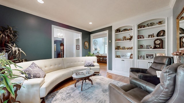 living room featuring crown molding, light hardwood / wood-style floors, and built in features