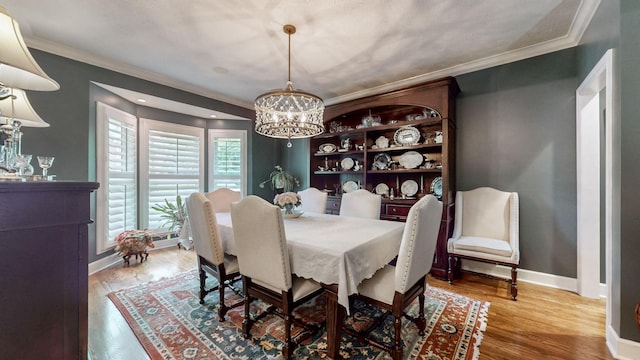 dining space with crown molding, a chandelier, and hardwood / wood-style flooring