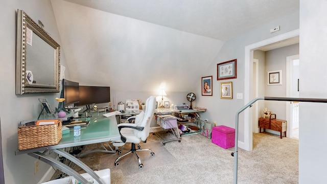 carpeted home office featuring lofted ceiling