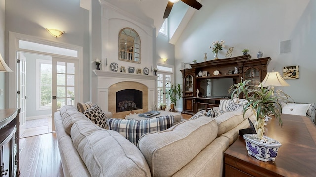 living room featuring light hardwood / wood-style flooring, high vaulted ceiling, and ceiling fan