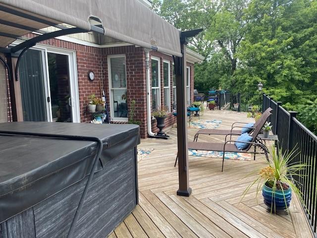 wooden terrace with a hot tub and a pergola