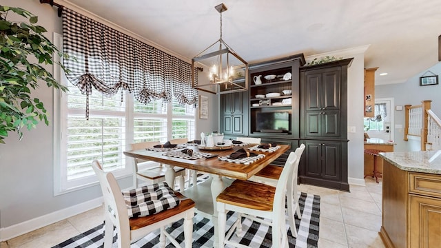 dining room with an inviting chandelier, light tile patterned floors, and crown molding