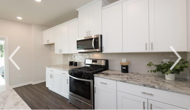 kitchen with white cabinetry, light stone countertops, dark hardwood / wood-style flooring, and stainless steel appliances