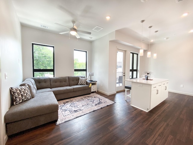 living room with ceiling fan and dark wood-type flooring