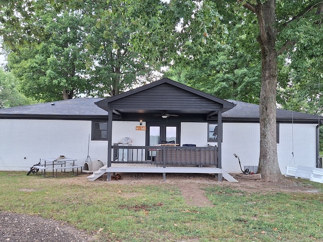 view of front of house featuring a wooden deck, ceiling fan, and a front yard