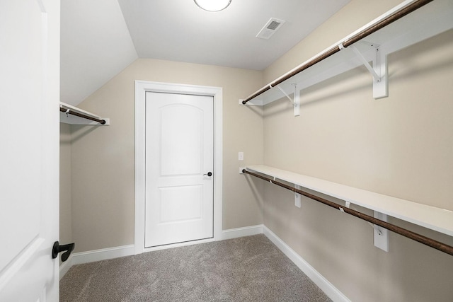 walk in closet featuring carpet flooring and vaulted ceiling