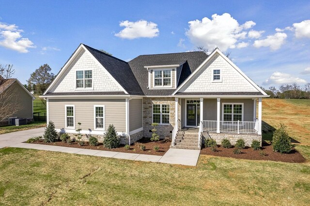 craftsman-style house with central AC, a front yard, and covered porch