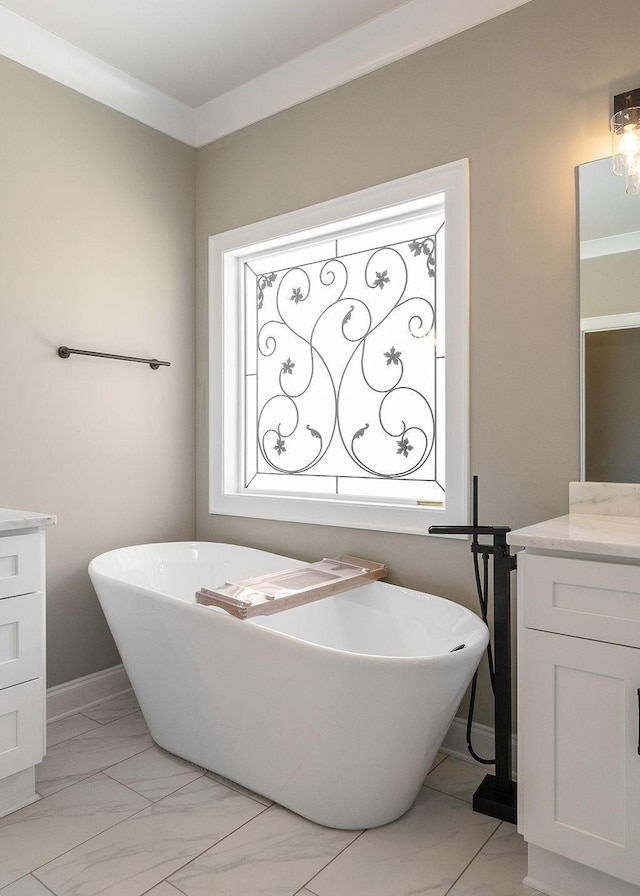 bathroom featuring ornamental molding, vanity, and a tub