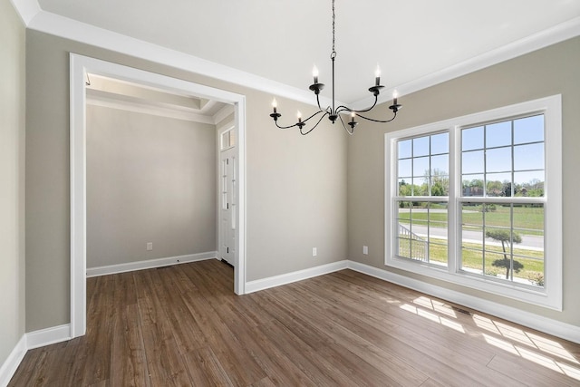 unfurnished dining area featuring crown molding, a chandelier, and hardwood / wood-style floors