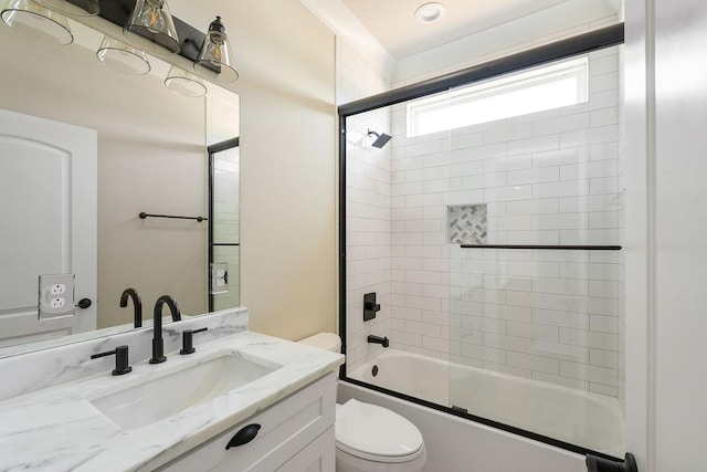 full bathroom featuring enclosed tub / shower combo, vanity, and toilet