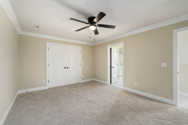 unfurnished bedroom with light carpet, connected bathroom, crown molding, and a closet