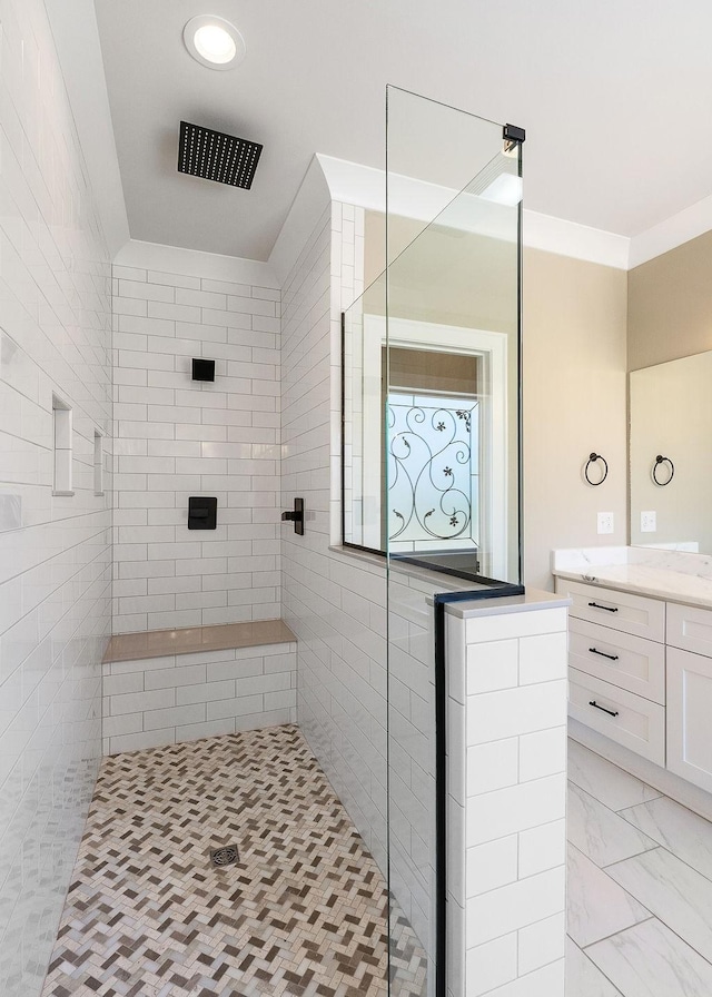 bathroom featuring crown molding, tiled shower, and vanity