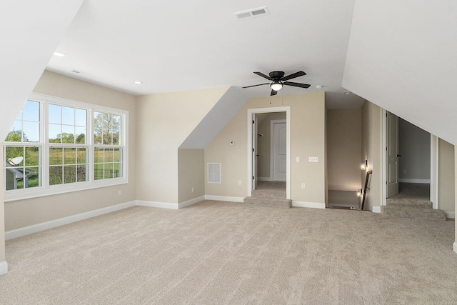 additional living space with ceiling fan, vaulted ceiling, and light carpet