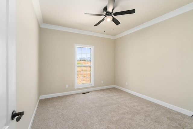 unfurnished room with crown molding, light colored carpet, and ceiling fan