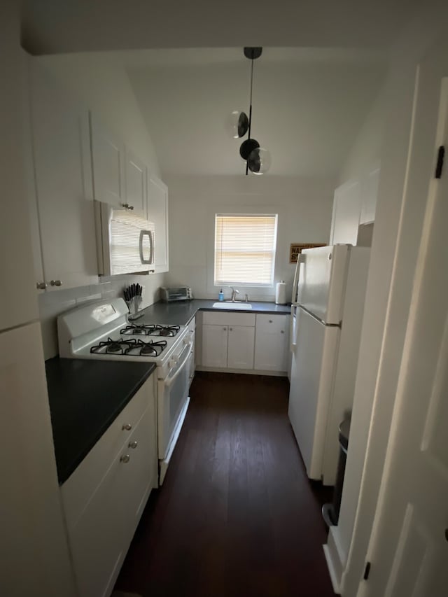 kitchen featuring sink, dark hardwood / wood-style flooring, white cabinetry, and white appliances