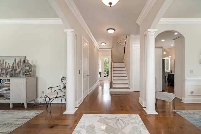 entrance foyer with crown molding, dark wood-type flooring, and decorative columns