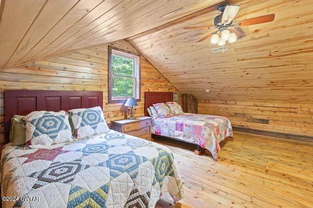 bedroom with lofted ceiling, wood walls, wood ceiling, light wood-type flooring, and ceiling fan