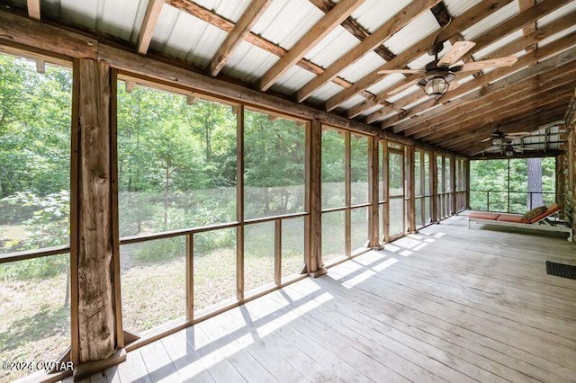 unfurnished sunroom with ceiling fan and vaulted ceiling