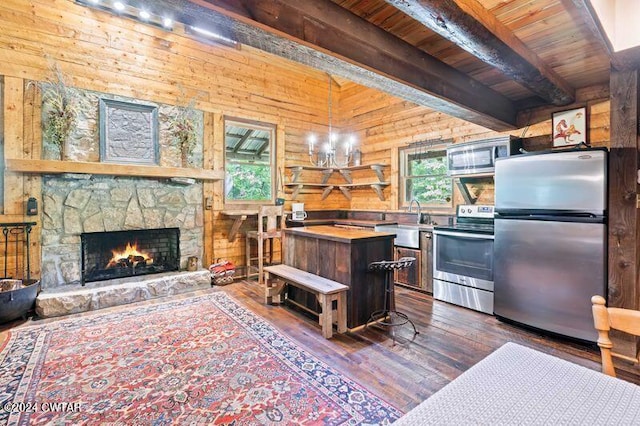 kitchen with wood ceiling, dark hardwood / wood-style floors, a kitchen island, stainless steel appliances, and beam ceiling