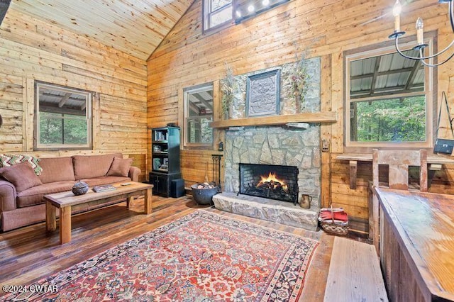 living room featuring plenty of natural light, wooden ceiling, hardwood / wood-style floors, and a stone fireplace