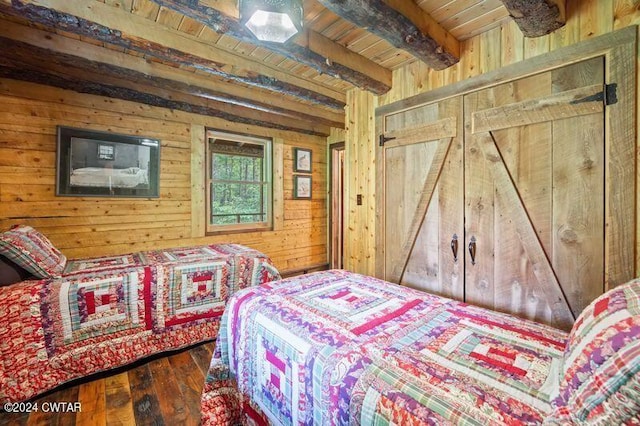 bedroom with wooden ceiling, beam ceiling, hardwood / wood-style floors, and wood walls