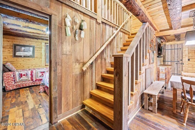 staircase featuring hardwood / wood-style floors and wooden walls