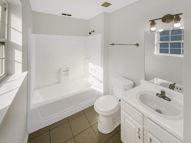 full bathroom with washtub / shower combination, toilet, vanity, and tile patterned flooring