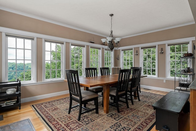 dining room with crown molding, a notable chandelier, hardwood / wood-style flooring, and plenty of natural light