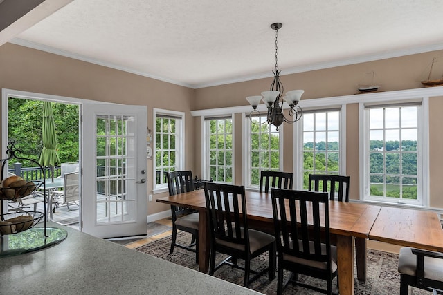 dining space with a notable chandelier, crown molding, and a textured ceiling